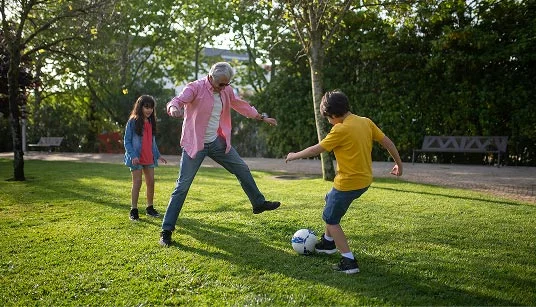 kids-playing A family outside playing soccer on grass